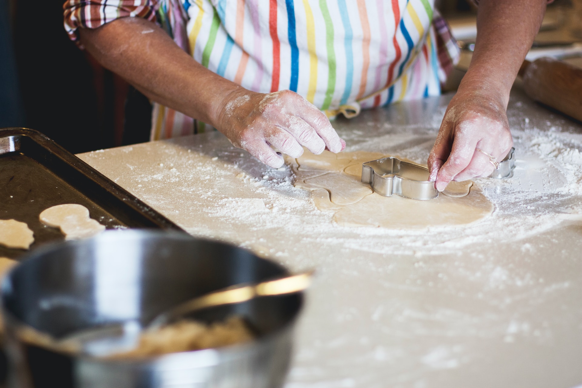 Person cutting out pastry with pastry cutter during cooking lesson