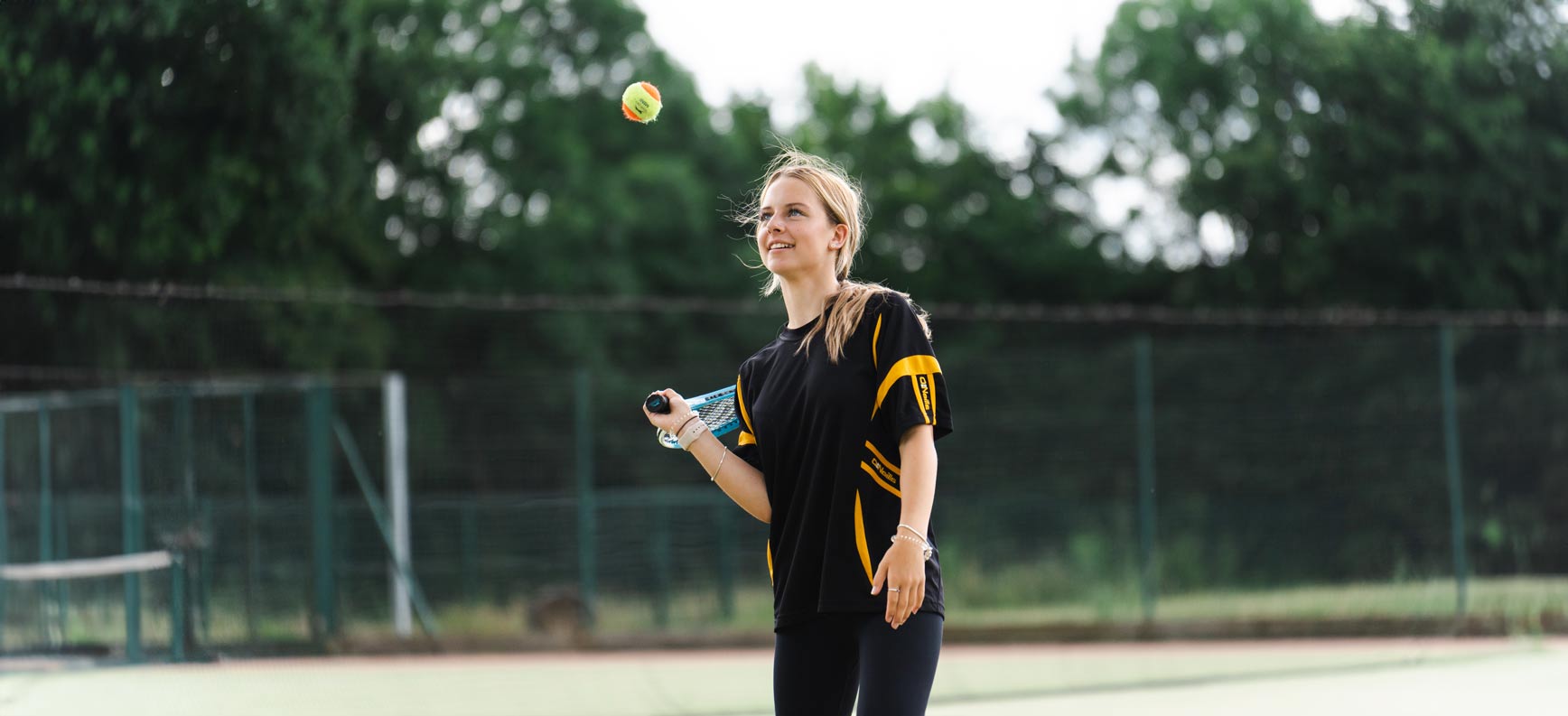 school pupils hits tennis ball with racket